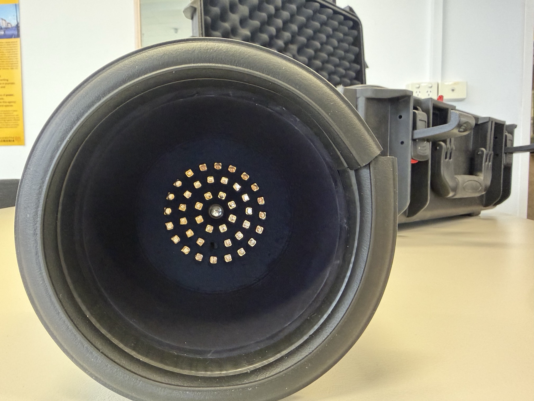 Concentric rings of narrowband emitters around the Spectrophage detector port inside the light-trapped housing